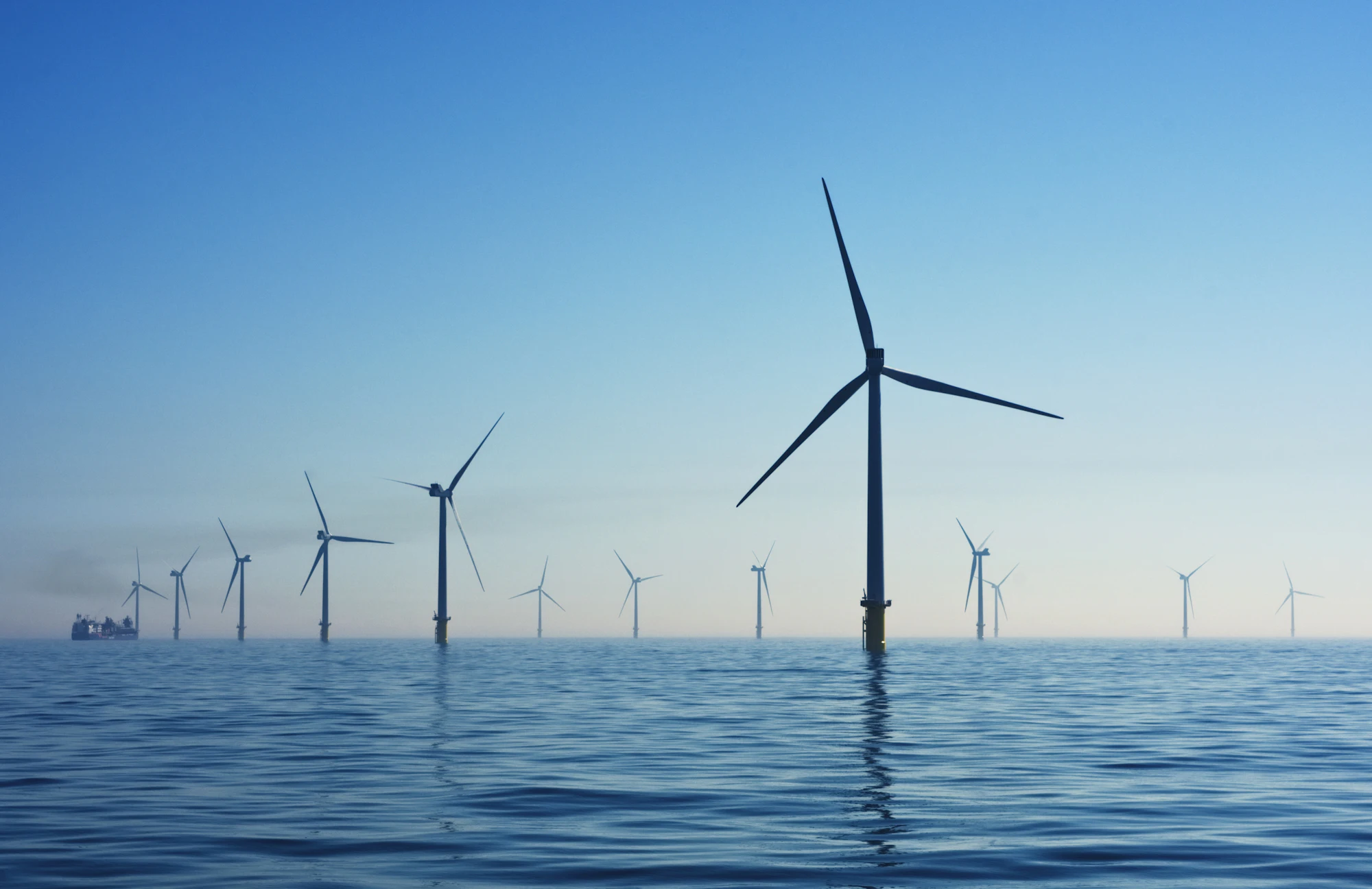 Offshore wind turbines standing in a calm blue sea