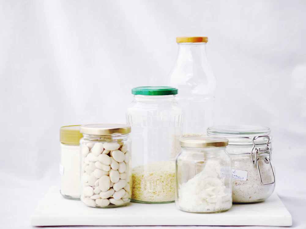 Glass jars of dry goods grouped on a white table