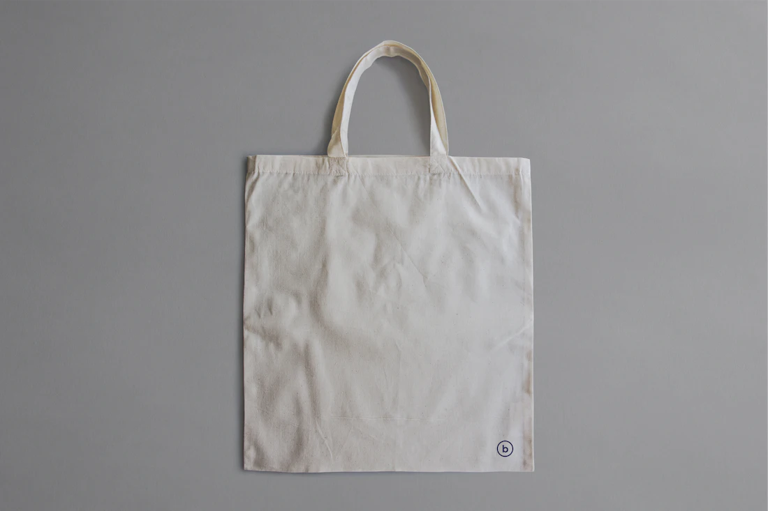 A natural cotton tote bag on a grey surface